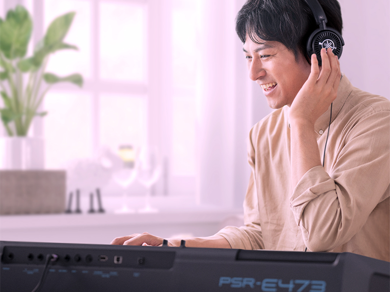 Man enjoying PSR-E473 connected to HPH-150